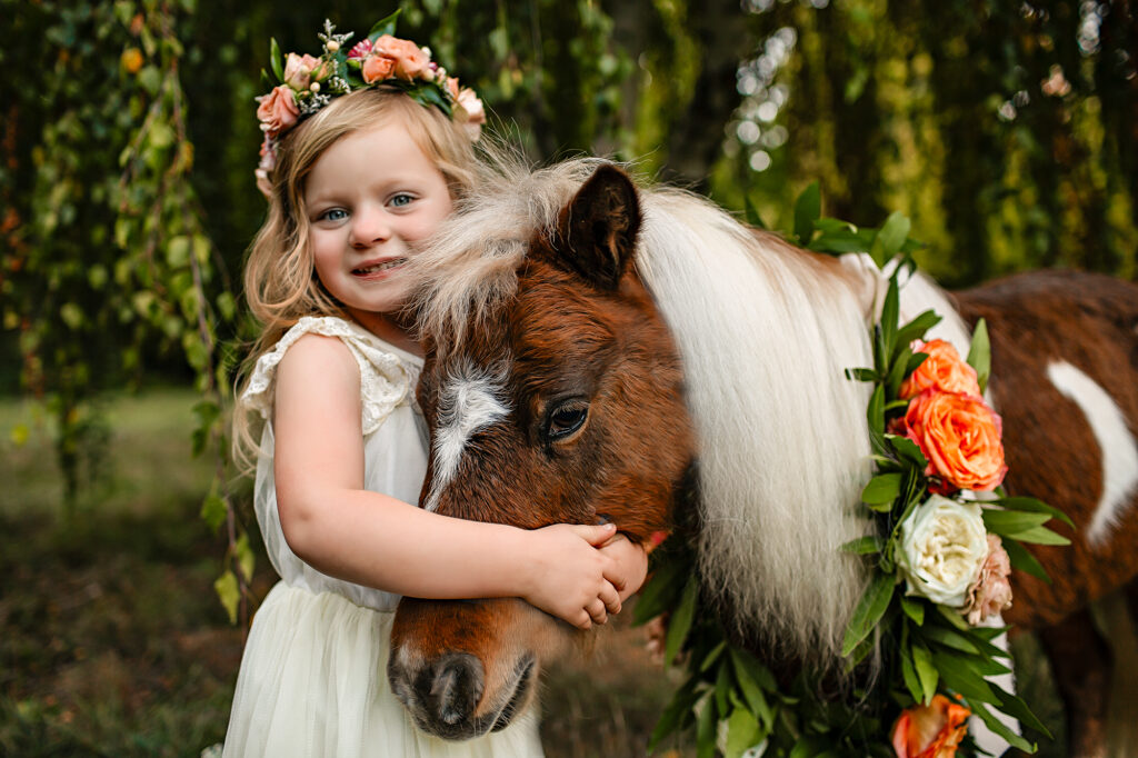 little girl hugs rescue pony