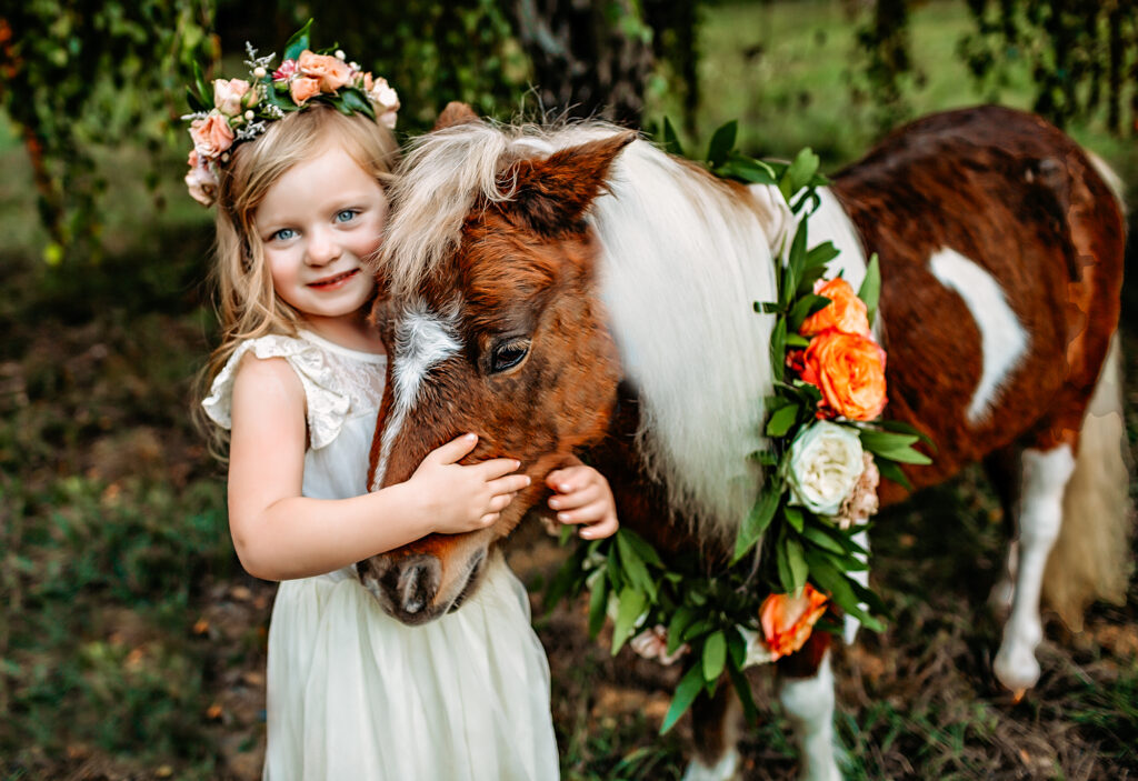 little girl hugs rescue pony